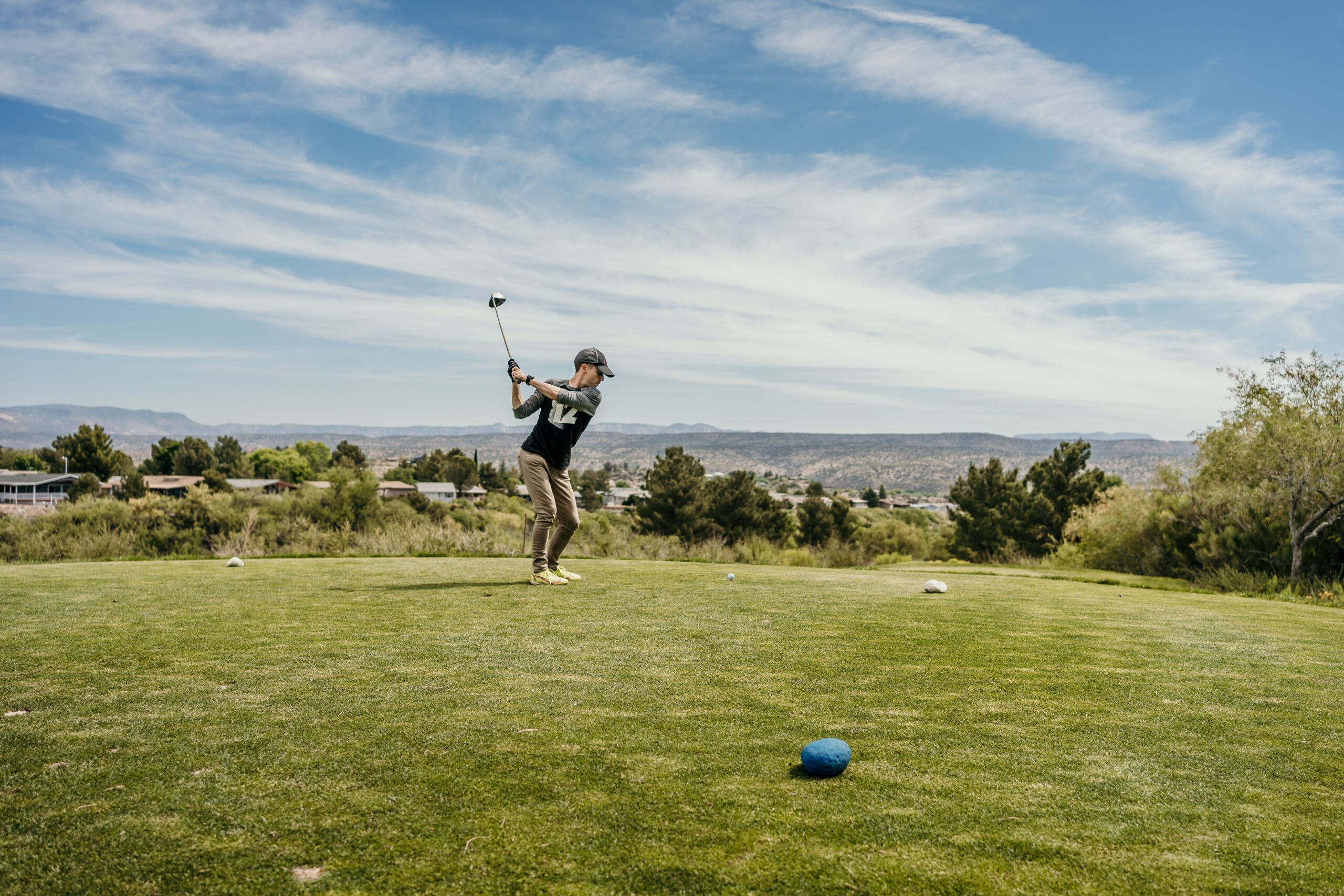 Coyote Trails Golf Course, Cottonwood, AZ Golfer taking a swing on a scenic green golf course with mountains in background